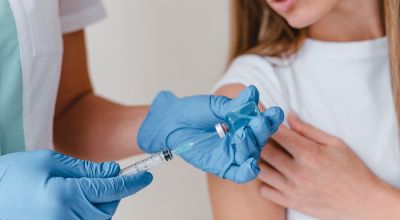 medico-con-i-guanti-che-prepara-il-vaccino-per-una-donna medico-con-i-guanti-che-prepara-il-vaccino-per-una-donna